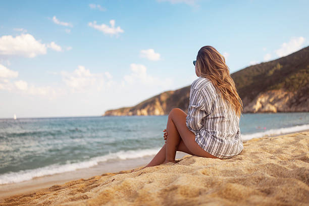istock Woman Relaxing on a Serene Sandy Beach with Ocean Views 2236107533