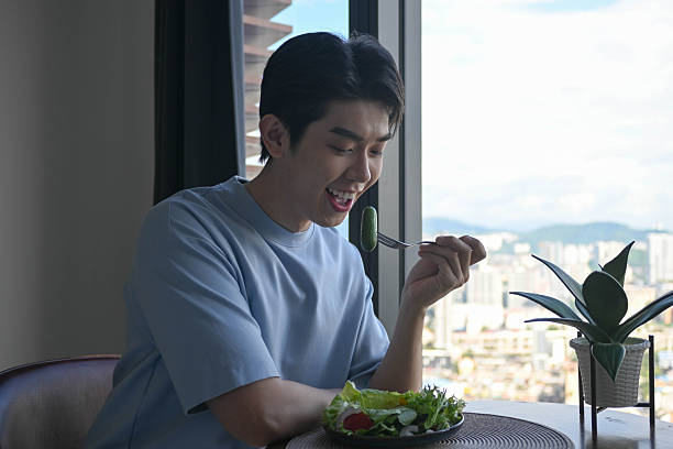 Asian man relaxing at home while enjoying a delicious and nutritious meal.