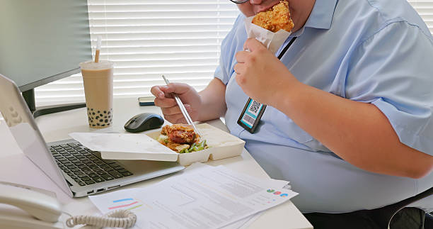 istock obese businessman office worker eating at desk 2236107870