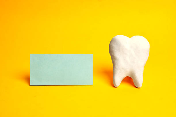 A blank card placed next to a tooth provides space for a dental clinic message, appointment details, or branding within a healthcare communication layout.