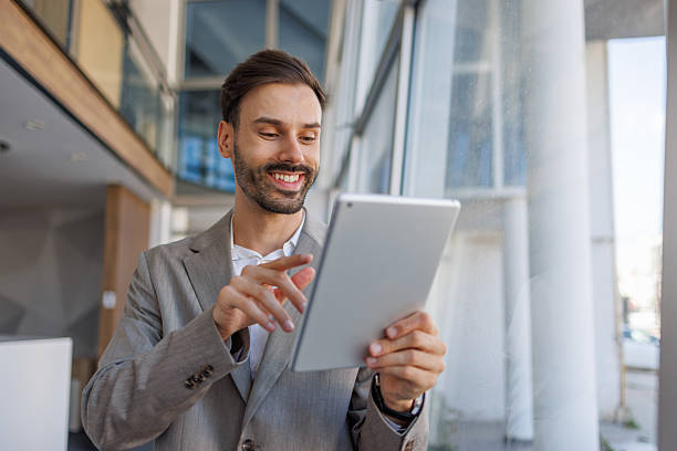 istock Businessman smiling and using digital tablet in office 2236108274
