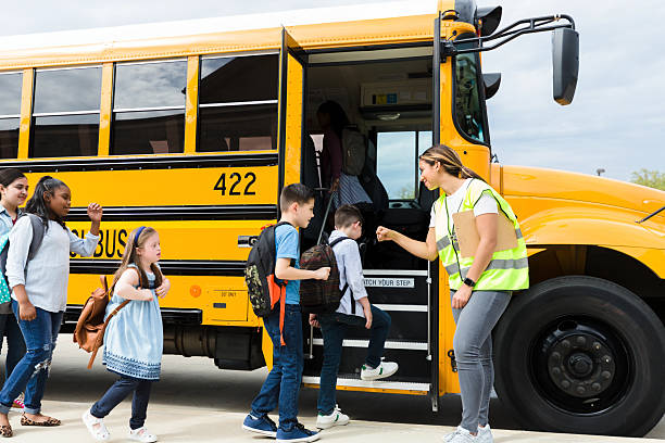 istock Happy Students Boarding School Bus with Teacher 2236109308