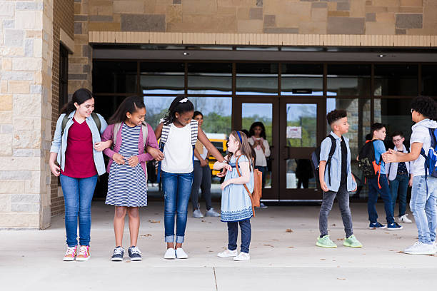 istock Elementary School Girls Smiling and Talking Outside School Building 2236109314
