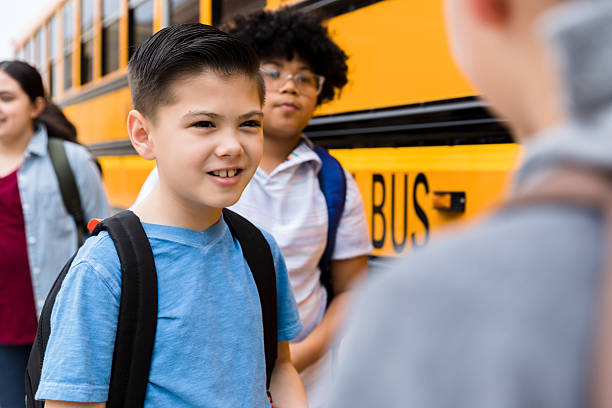 istock Happy Elementary School Children Talking Near School Bus 2236109321