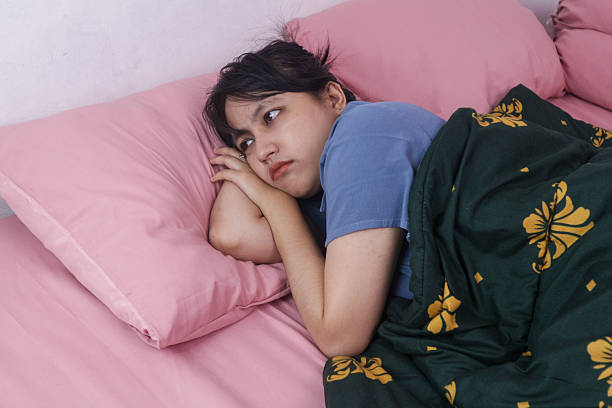 Depressed young woman lying in bed cannot sleep from insomnia