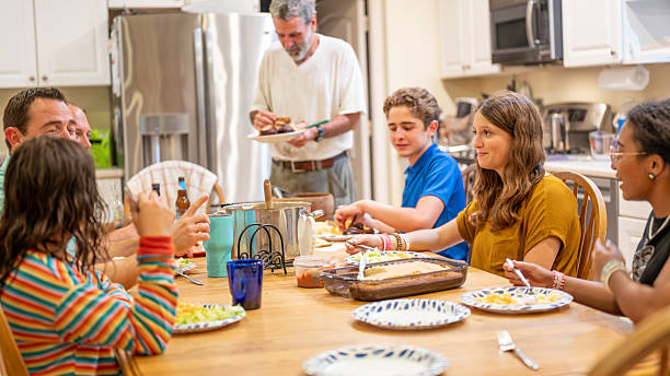 istock Modest diverse extended middle class American family eating dinner together at home around a dining room table 2236110130