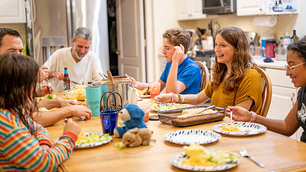 istock Modest diverse extended middle class American family eating dinner together at home around a dining room table 2236110169