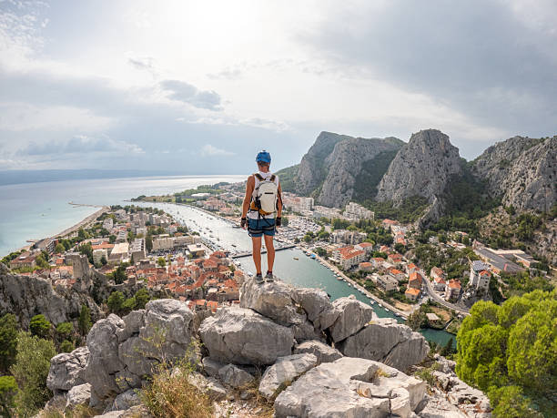 istock Hiker Overlooking Coastal Town and Harbor 2236110341