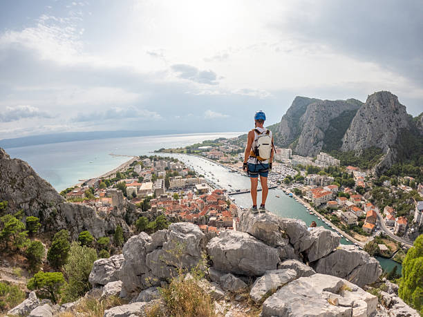 istock Hiker Overlooking Coastal Town and Harbor 2236110343