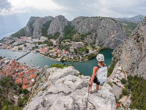 istock Woman Rock Climber Overlooking Coastal Town 2236110390