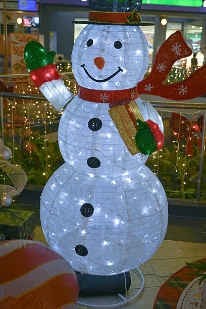 Luminous inflatable figure of Snowman decorating front yard at night. Everett, WA, USA - November 2022