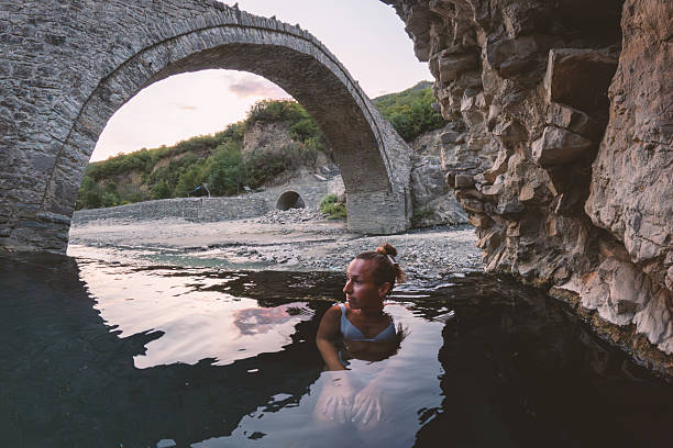 istock Woman Relaxing in River Near Stone Bridge 2236113254