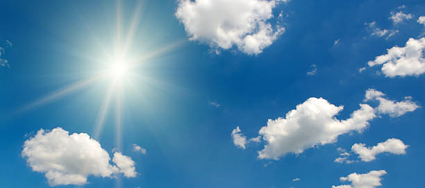 istock The Bright And Powerful Sun Shines With A Beautiful Starburst Effect In A Pure Blue Sky With Scattered White Fluffy Clouds On A Clear And Serene Day. 2236113262