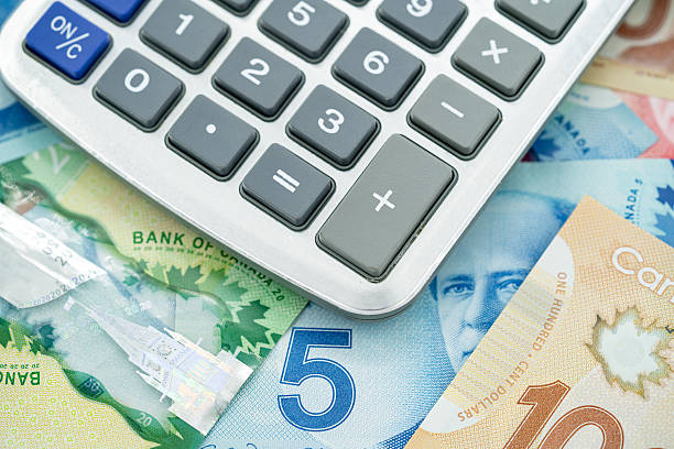 istock Calculator with Canadian dollar banknotes in background. 2236115746