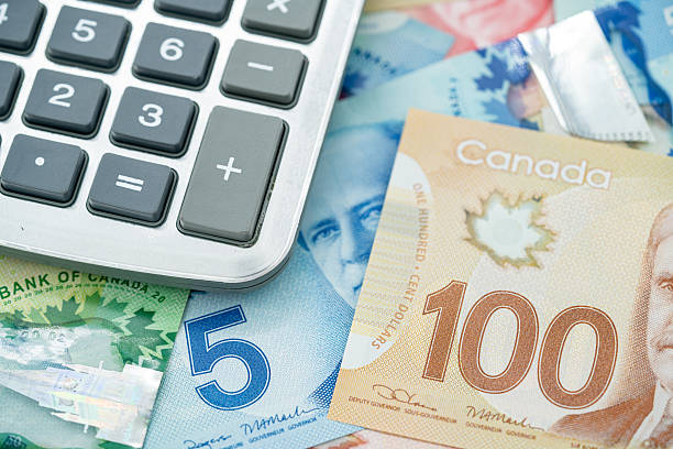 istock Calculator with Canadian dollar banknotes in background. 2236115827