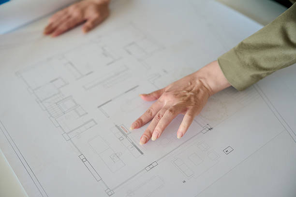 istock Architect hands pointing at house blueprint design 2236120092
