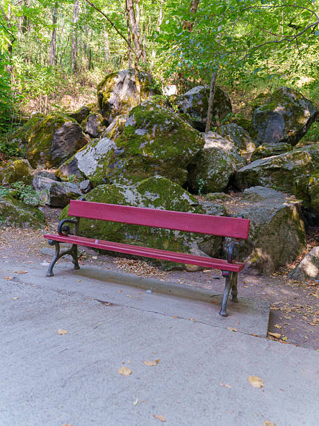 Empty sitting bench and red metal wall