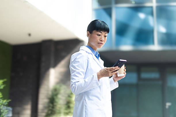 istock Asian doctor checking smartphone during coffee break 2236122382