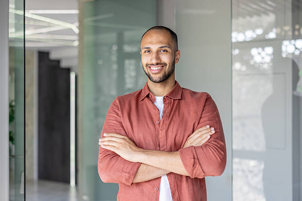 istock Confident man smiling indoors with arms crossed at modern workplace 2236123298