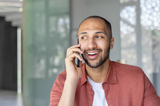 istock A happy man is having a phone conversation, showing a joyful expression and looking away. 2236123339