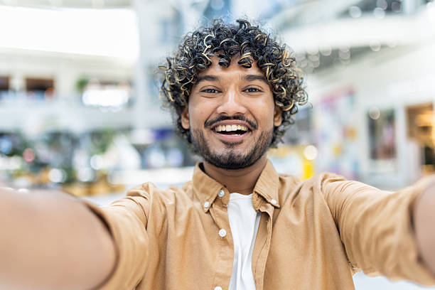 istock Happy young man taking a selfie indoors at a bright modern location 2236123983