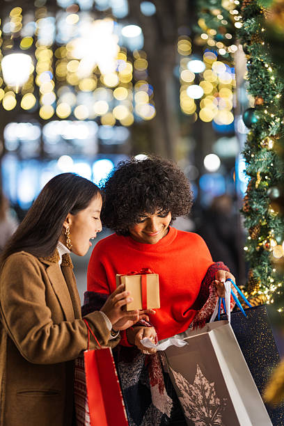 istock Diverse young women exchanging gift while christmas shopping 2236126705