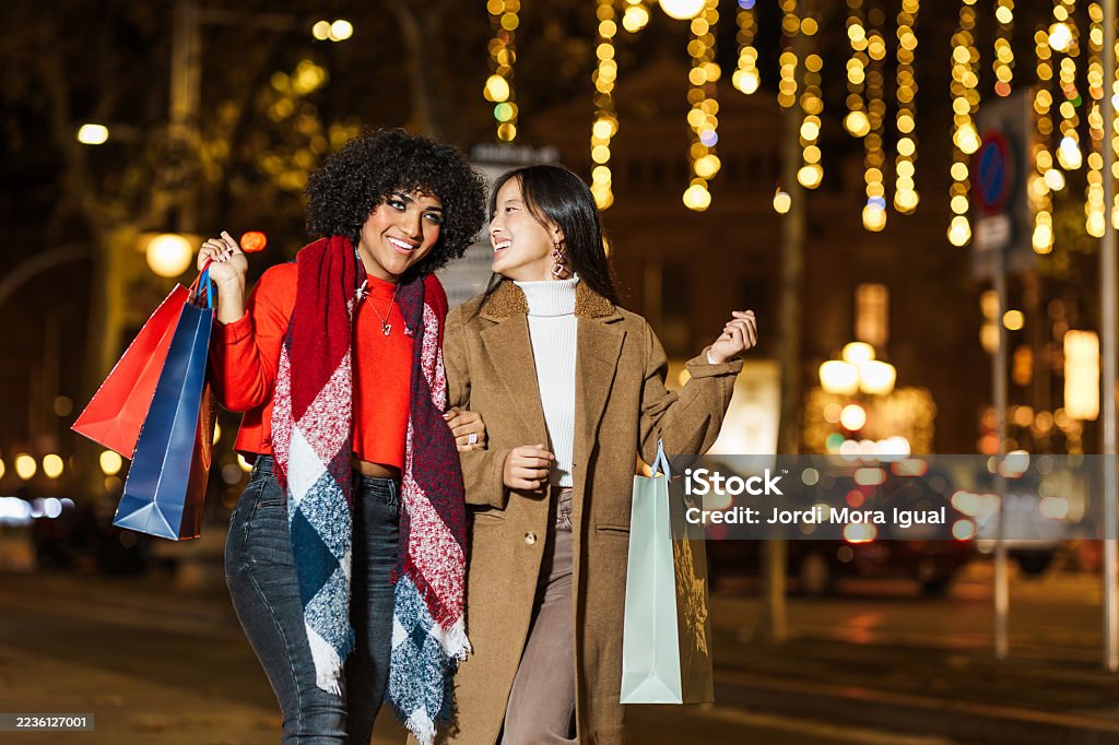 Glückliche junge Frauen genießen die Weihnachtseinkaufsnacht in der Stadt - Lizenzfrei 20-24 Jahre Stock-Foto Glückliche junge Frauen genießen die Weihnachtseinkaufsnacht in der Stadt - Lizenzfrei 20-24 Jahre Stock-Foto