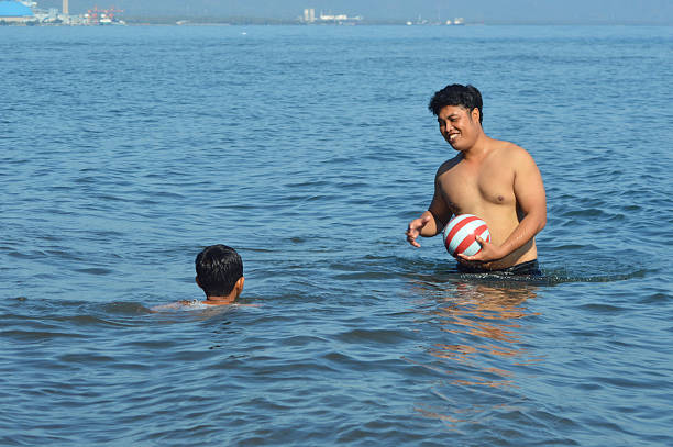 Boy on a sandy beach, enjoying large waves, Bali, Indonesia