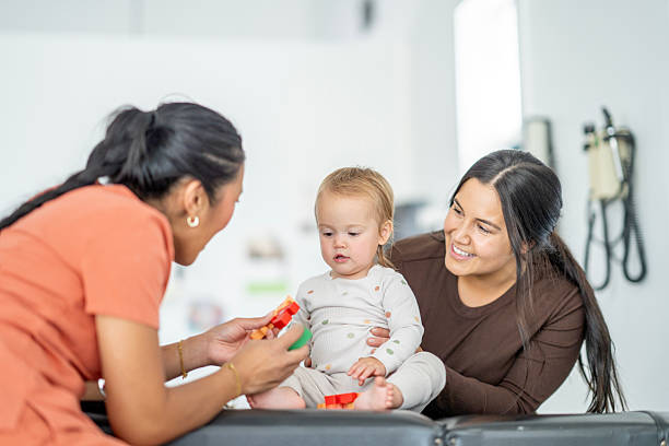 Asian Nurse Interacting with Baby While Parent Observes in a Modern Clinic