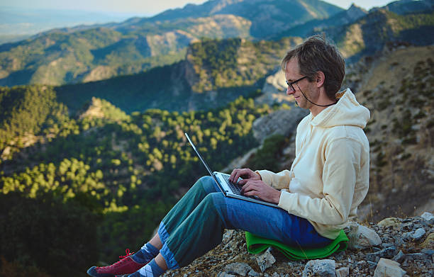 istock Person Using Laptop Outdoors in Scenic Mountainous Nature Setting 2236131702