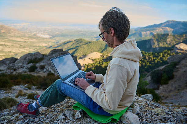 istock Remote Worker Using Laptop While Sitting Outdoors in a Scenic Mountain Landscape 2236131735