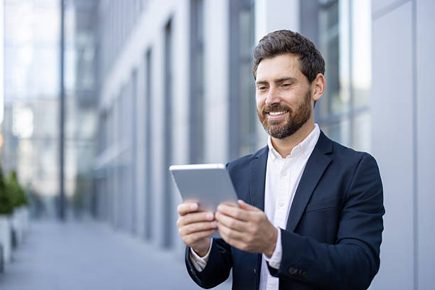 istock Confident businessman using digital tablet in urban professional setting 2236132167