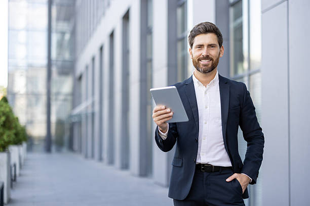 istock Confident businessman holding a tablet in a modern urban environment 2236132175