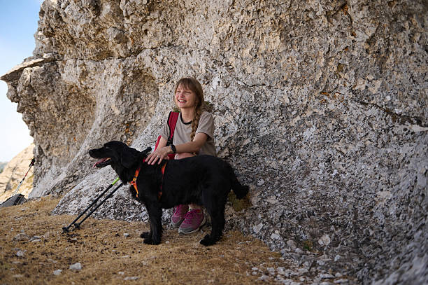 istock Woman Relaxing During a Hike with Her Black Dog in a Natural Setting 2236132189