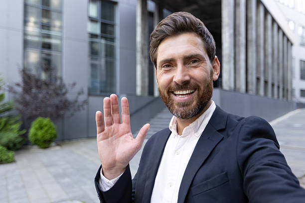 istock Business professional smiling outdoors while waving and engaging with the audience 2236132243