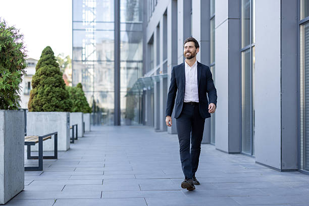 istock A successful businessman strides confidently toward the camera, smiling with a positive attitude. 2236132270