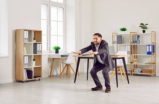 istock Business man in a suit doing physical exercises during a break at work in the office 2236132843