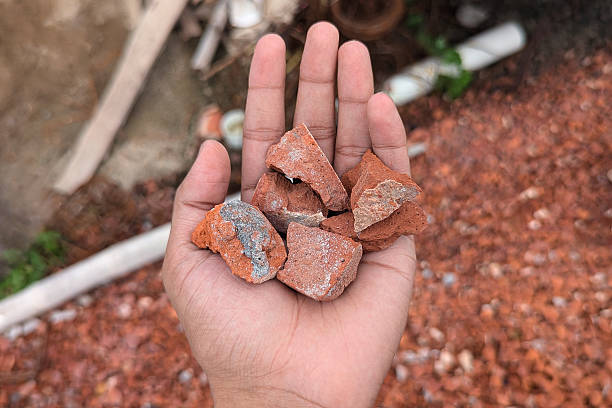 istock Small pieces of red clay bricks on hand 2236134535