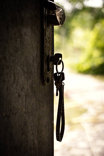 Keys in a door lock against a natural background, rustic style, atmospheric photo.