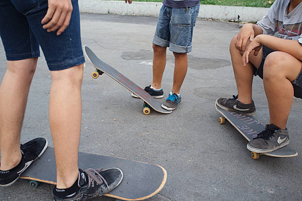 Ho Chi Minh City, Vietnam - February 15, 2014: Street life, unrecognizable teenage boys gathered together outdoors and sharpening skills in skateboarding, close-up