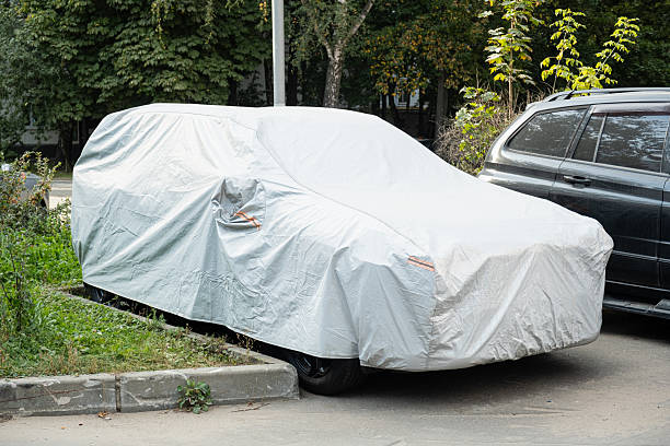 istock Parked car covered with protective tarp outdoors 2236148619