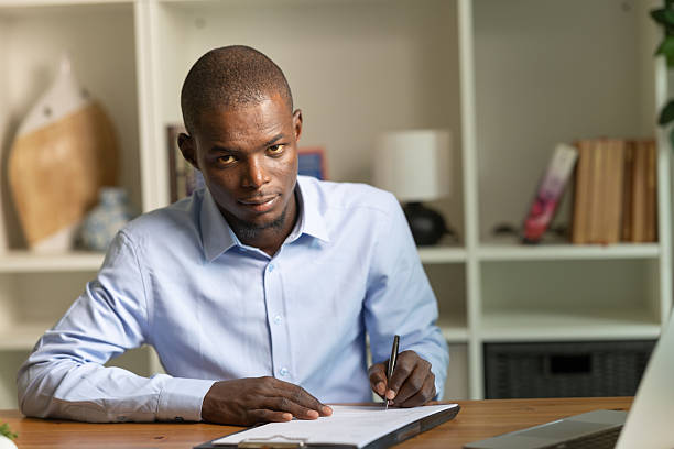 istock African man signing document, working in home office 2236150740