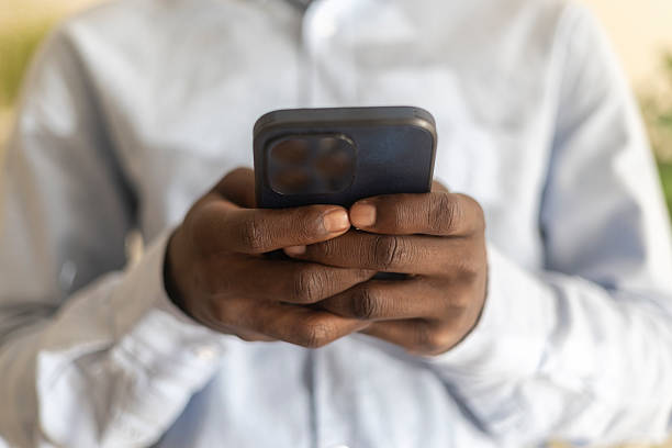 istock Black man's hands holding a smartphone and typing, communicating with technology 2236151406