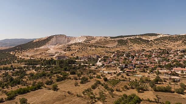 Excavation site and settlement fabric. Visual and thematic encounter between natural landscape and industrial and agricultural structures. Burdur, Turkey.