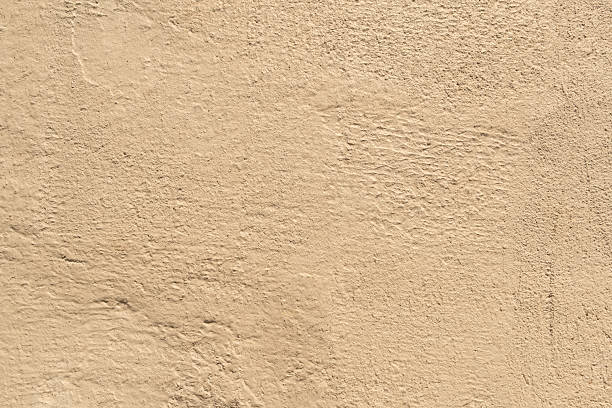 istock abstract view of a textured wall with a rough, uneven surface. The earthy-toned plaster has a granular texture with areas of subtle ripples and bumps 2236153629