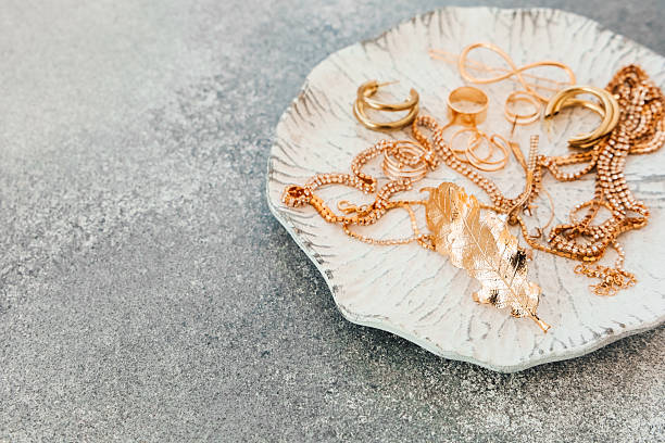 istock Gold jewelry displayed on a decorative plate resting on a textured surface 2236154093