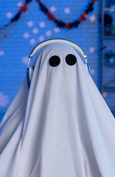 istock A person dressed as a ghost poses in a room decorated for Halloween with blue lighting 2236157880