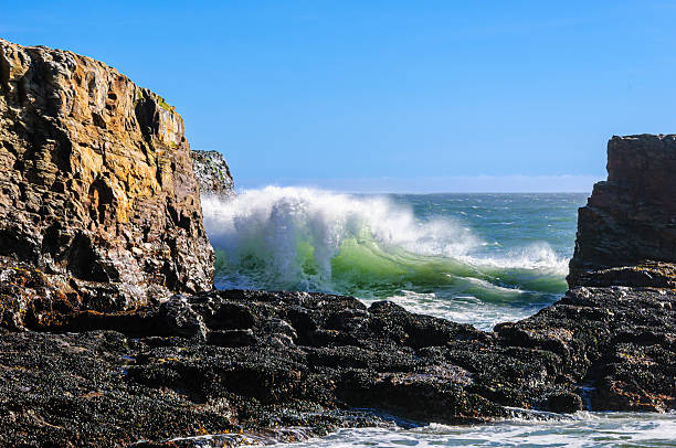 Ocean Waves crashing along California Coast, seen through the rock formation Davenport Crack.Taken at Davenport Crack, Davenport, California, USA