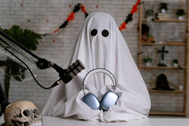 istock Funny ghost in a white sheet recording a podcast or blog 2236163087