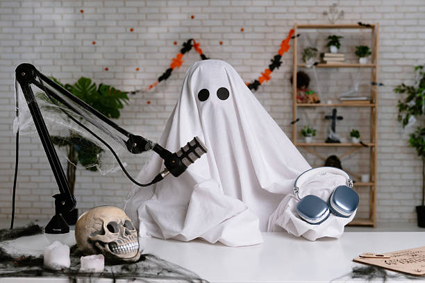 istock Funny ghost in a white sheet recording a podcast or blog 2236163293